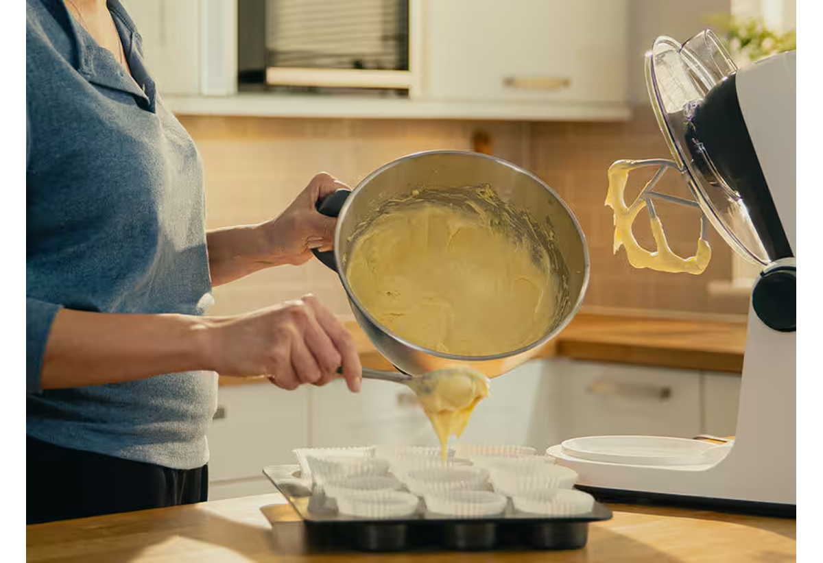 Μια γυναίκα φορμάρει muffins από μείγμα που έφτιαξε με τη χρήση της κουζινομηχανής.
